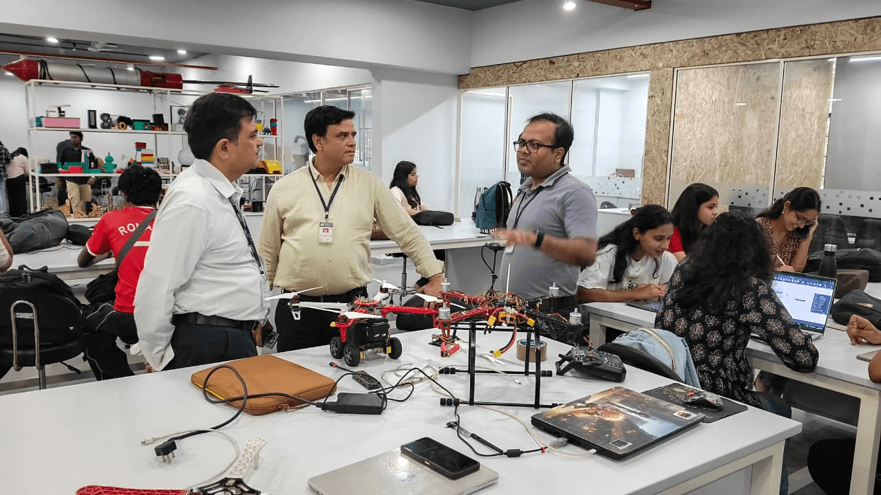 A laboratory discussion beside a large multirotor prototype and student project work
